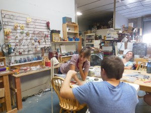 Mary Ann LaRoche of SEEDs for Autism works with a student in her warehouse which has many projects going simultaneously